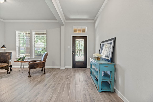 entrance foyer featuring crown molding, baseboards, and light wood finished floors