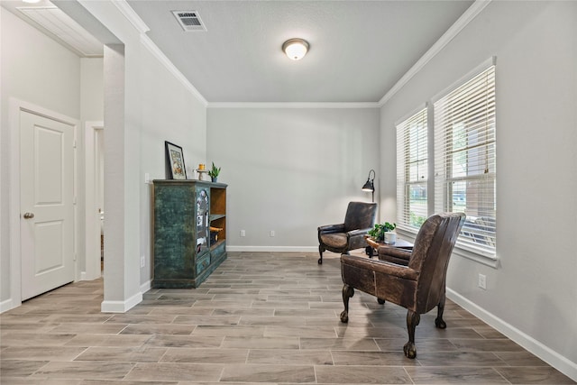 sitting room featuring baseboards, visible vents, ornamental molding, and wood finished floors