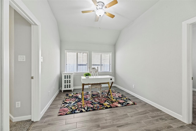 home office featuring a ceiling fan, baseboards, wood finished floors, and lofted ceiling