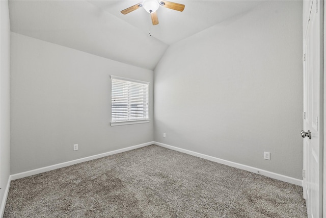 carpeted empty room featuring a ceiling fan, baseboards, and vaulted ceiling
