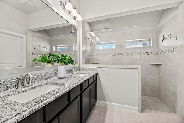 bathroom featuring visible vents, a sink, and a walk in shower