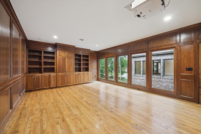 5040 Fieldwood Dr, Houston, TX 77056 - unfurnished living room featuring crown molding, light wood-style flooring, visible vents, and wood walls