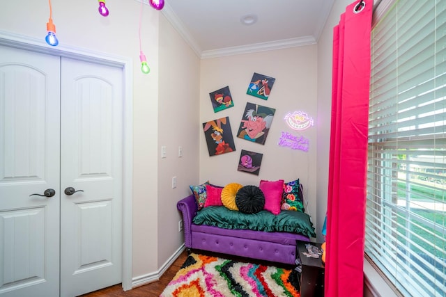 bedroom with crown molding, baseboards, and wood finished floors