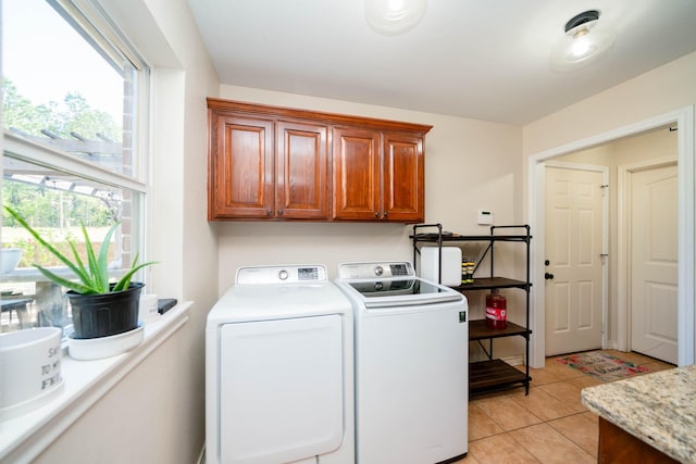 clothes washing area featuring cabinet space, independent washer and dryer, and light tile patterned floors