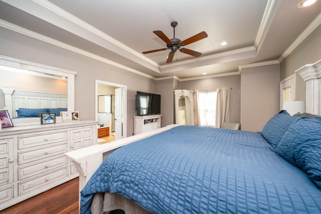 bedroom with ornamental molding, dark wood-style flooring, recessed lighting, a raised ceiling, and connected bathroom