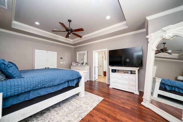 bedroom with recessed lighting, a raised ceiling, ornamental molding, and dark wood-style flooring