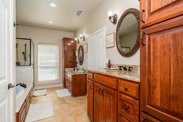 full bath with a sink, a shower with shower door, tile patterned floors, two vanities, and visible vents