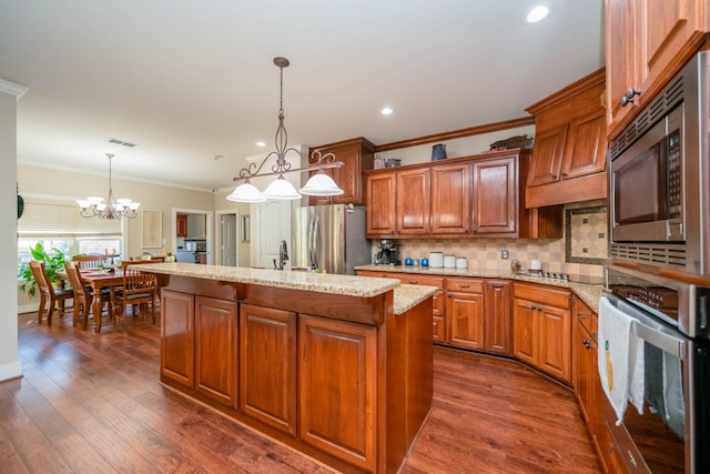 kitchen featuring a kitchen island with sink, visible vents, crown molding, a notable chandelier, and stainless steel appliances