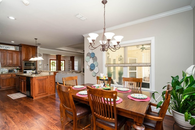 dining area with crown molding, visible vents, dark wood-style floors, and an inviting chandelier