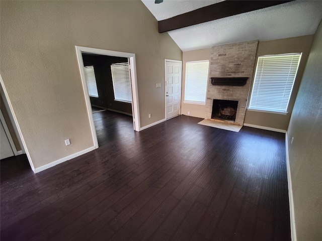 unfurnished living room featuring dark wood finished floors, a healthy amount of sunlight, vaulted ceiling with beams, and a fireplace