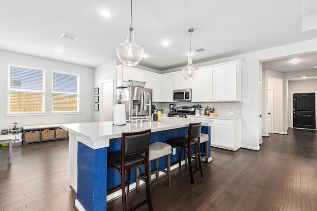 9118 Brixham Dr, Cypress, TX 77433 - kitchen with appliances with stainless steel finishes, light countertops, decorative backsplash, dark wood finished floors, and a kitchen bar