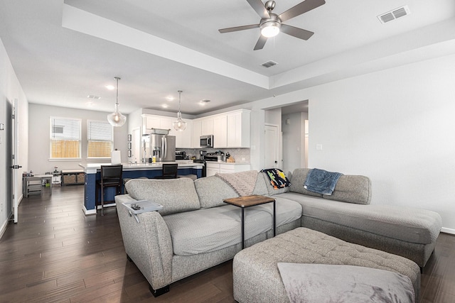 9118 Brixham Dr, Cypress, TX 77433 - living area featuring dark wood-style flooring, ceiling fan, baseboards, a raised ceiling, and recessed lighting