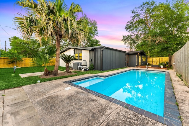 pool at dusk featuring a fenced backyard, a fenced in pool, a lawn, and central air condition unit