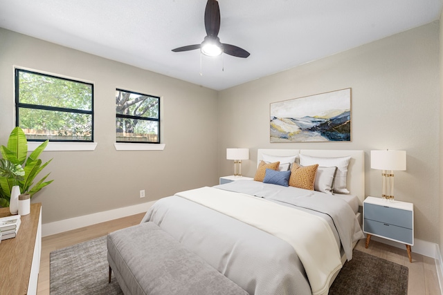 bedroom featuring light wood-type flooring, a ceiling fan, and baseboards