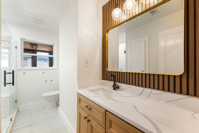 bathroom with visible vents, vanity, toilet, baseboards, and a marble finish shower