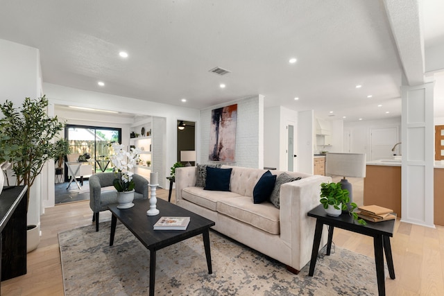 living room with visible vents, recessed lighting, and light wood-type flooring
