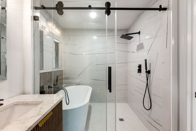 bathroom with a freestanding bath, a marble finish shower, vanity, and tile walls