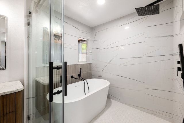 bathroom featuring tile walls, a freestanding bath, and a stall shower