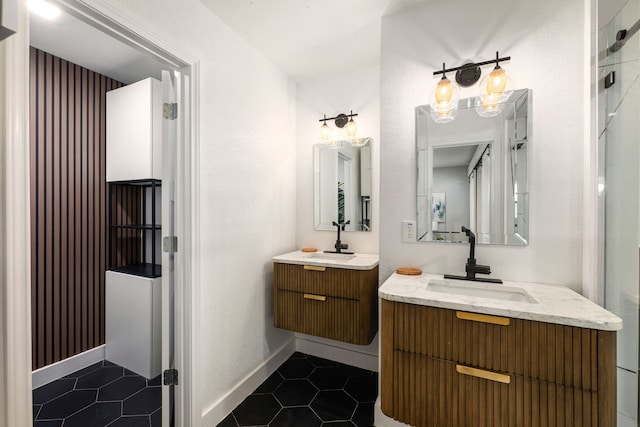 bathroom with baseboards, two vanities, a sink, and tile patterned flooring