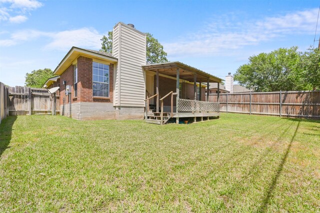 back of house featuring a fenced backyard, a chimney, a yard, and brick siding