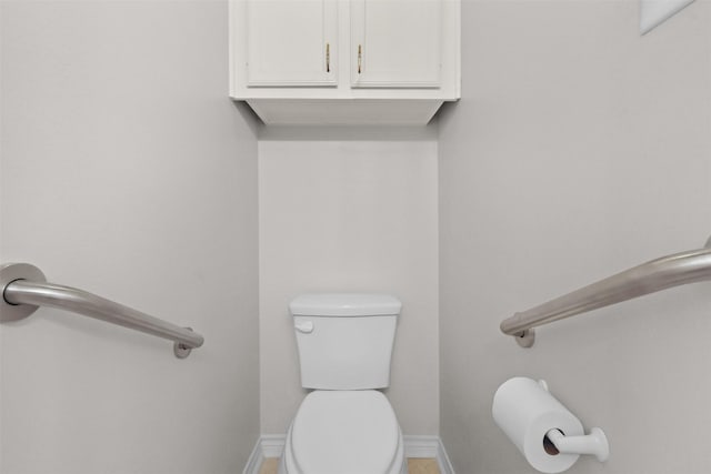 half bathroom featuring toilet and baseboards