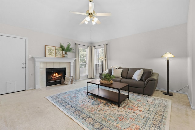 living room featuring a tiled fireplace, carpet, ceiling fan, and baseboards