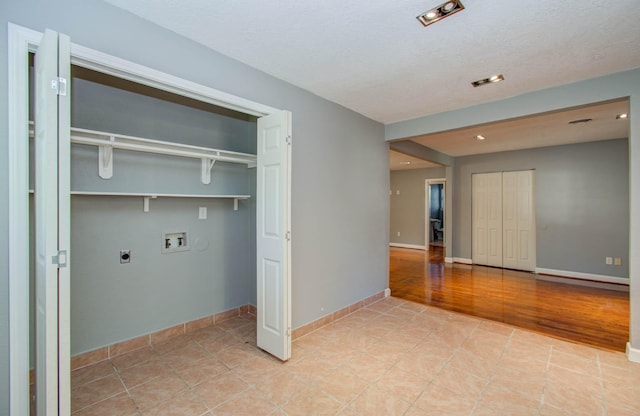 laundry area featuring laundry area, baseboards, hookup for a washing machine, light tile patterned floors, and hookup for an electric dryer