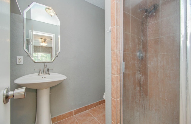 bathroom with tile patterned flooring, a stall shower, and toilet