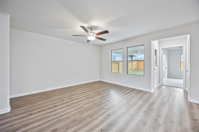 unfurnished room featuring baseboards, a ceiling fan, and wood finished floors