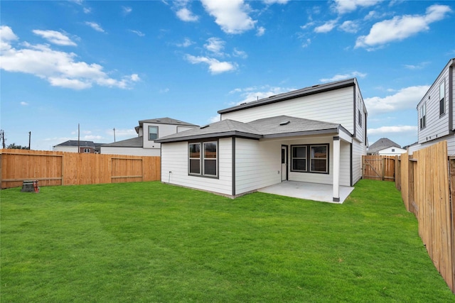 back of property with a patio, a fenced backyard, and a lawn