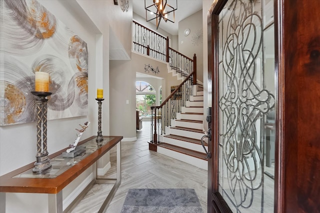 foyer featuring baseboards, stairs, and an inviting chandelier