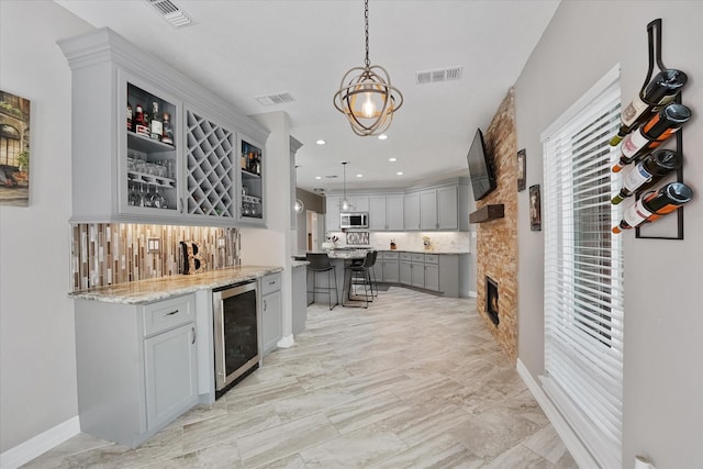 bar with stainless steel microwave, visible vents, decorative backsplash, and wine cooler