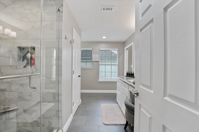 full bathroom with vanity, tile patterned floors, baseboards, visible vents, and a stall shower
