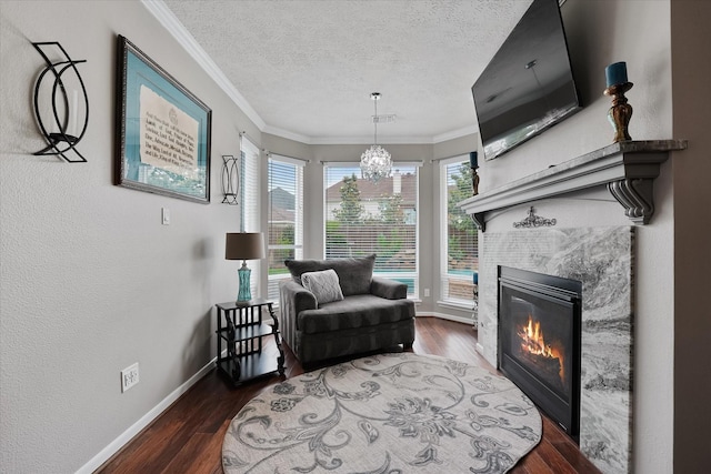 sitting room with baseboards, a textured ceiling, a tile fireplace, and wood finished floors