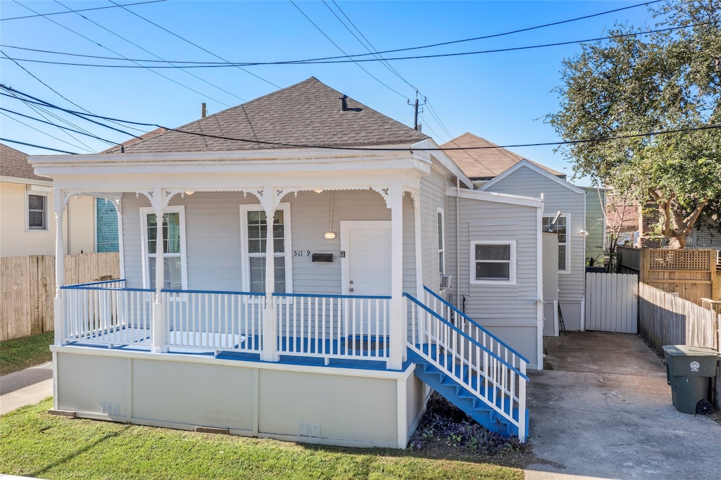 511 9th St, Galveston, TX 77550 - view of front of house featuring roof with shingles, covered porch, and fence
