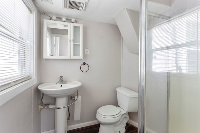 bathroom featuring baseboards, a wealth of natural light, toilet, and visible vents