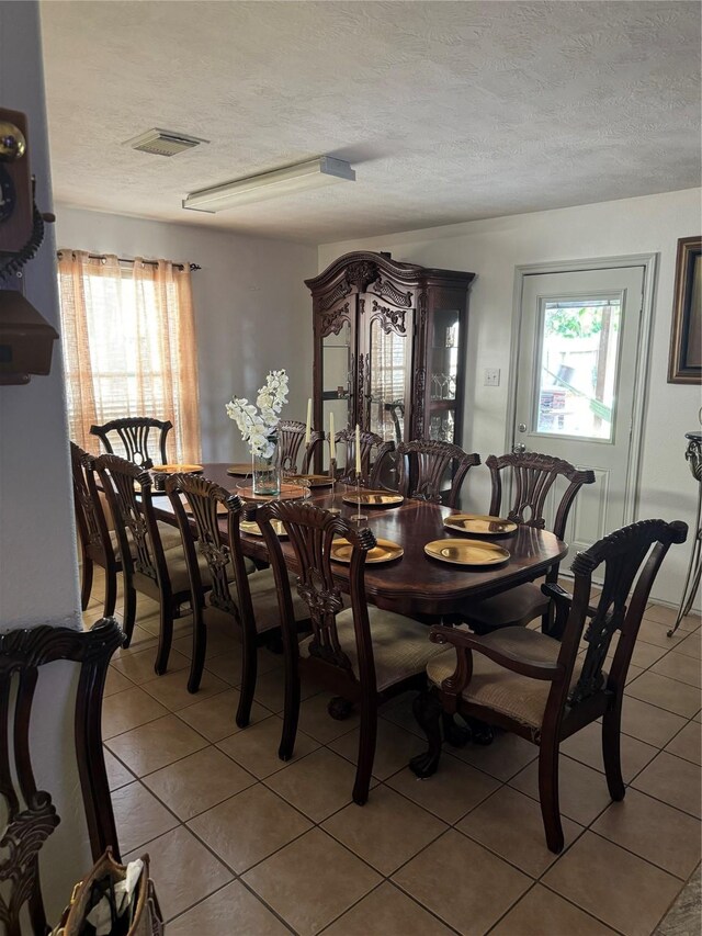 18207 Sea Branch Dr, Houston, TX 77084 - dining area featuring light tile patterned floors, plenty of natural light, a textured ceiling, and visible vents