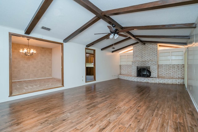 unfurnished living room with visible vents, wood finished floors, a fireplace, lofted ceiling with beams, and ceiling fan with notable chandelier