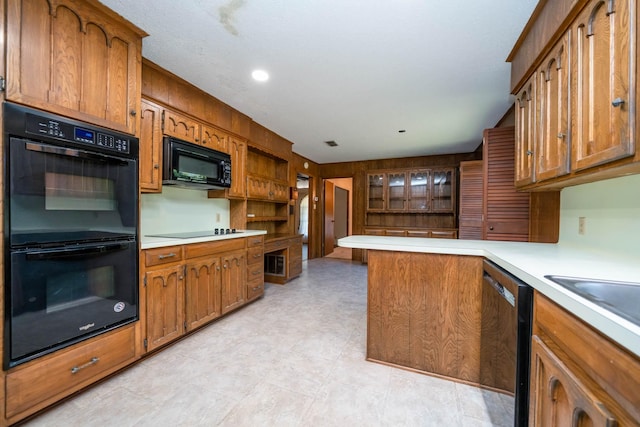 kitchen with light countertops, black appliances, and brown cabinets
