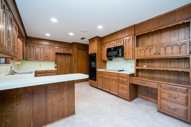 kitchen featuring a sink, light countertops, a peninsula, recessed lighting, and black appliances