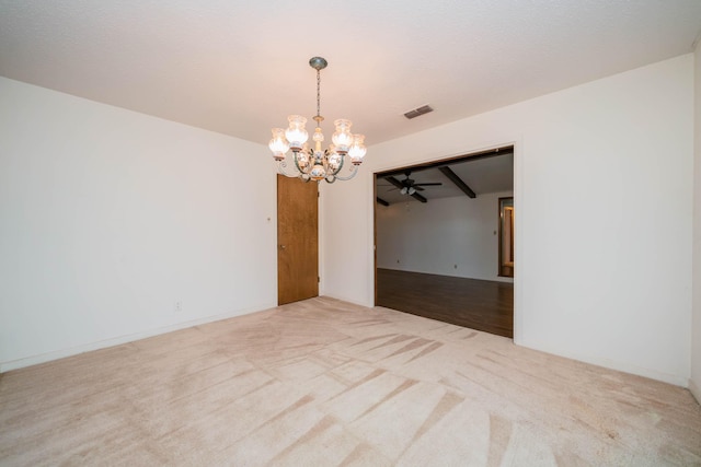empty room featuring visible vents, carpet, and ceiling fan with notable chandelier