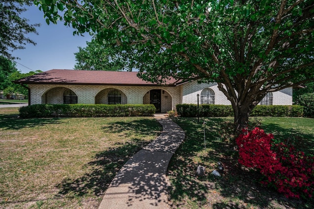 view of front of property with brick siding and a front yard