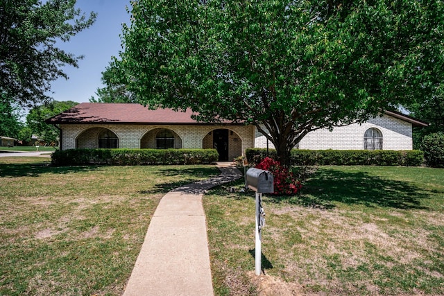 view of front of house featuring a front lawn and brick siding