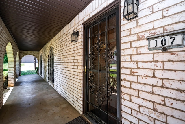 view of exterior entry featuring brick siding