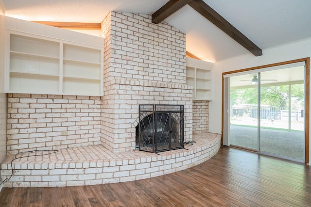 unfurnished living room featuring lofted ceiling with beams, wood finished floors, and a fireplace