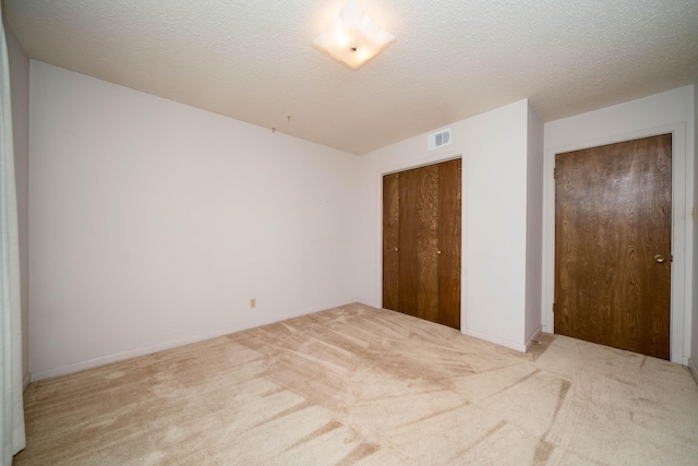 unfurnished bedroom featuring baseboards, carpet, a closet, and visible vents