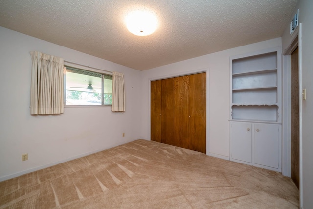 unfurnished bedroom with carpet floors, a closet, and a textured ceiling