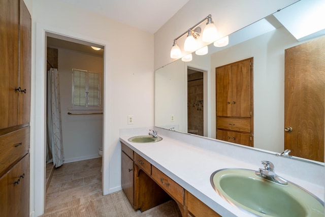 full bath featuring a sink, baseboards, toilet, and double vanity
