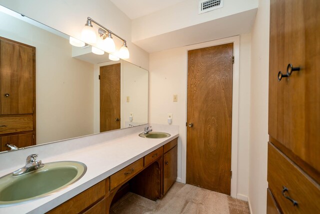 bathroom featuring double vanity, visible vents, and a sink