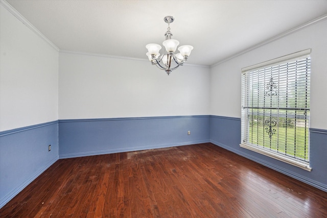 unfurnished room featuring an inviting chandelier, ornamental molding, baseboards, and wood finished floors